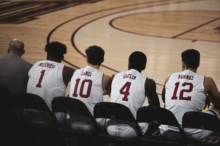 A diverse group of amateur basketball players filling out registration forms at a table with clipboards and documents, while a referee holds a rulebook, set in a bright community gym with basketball c