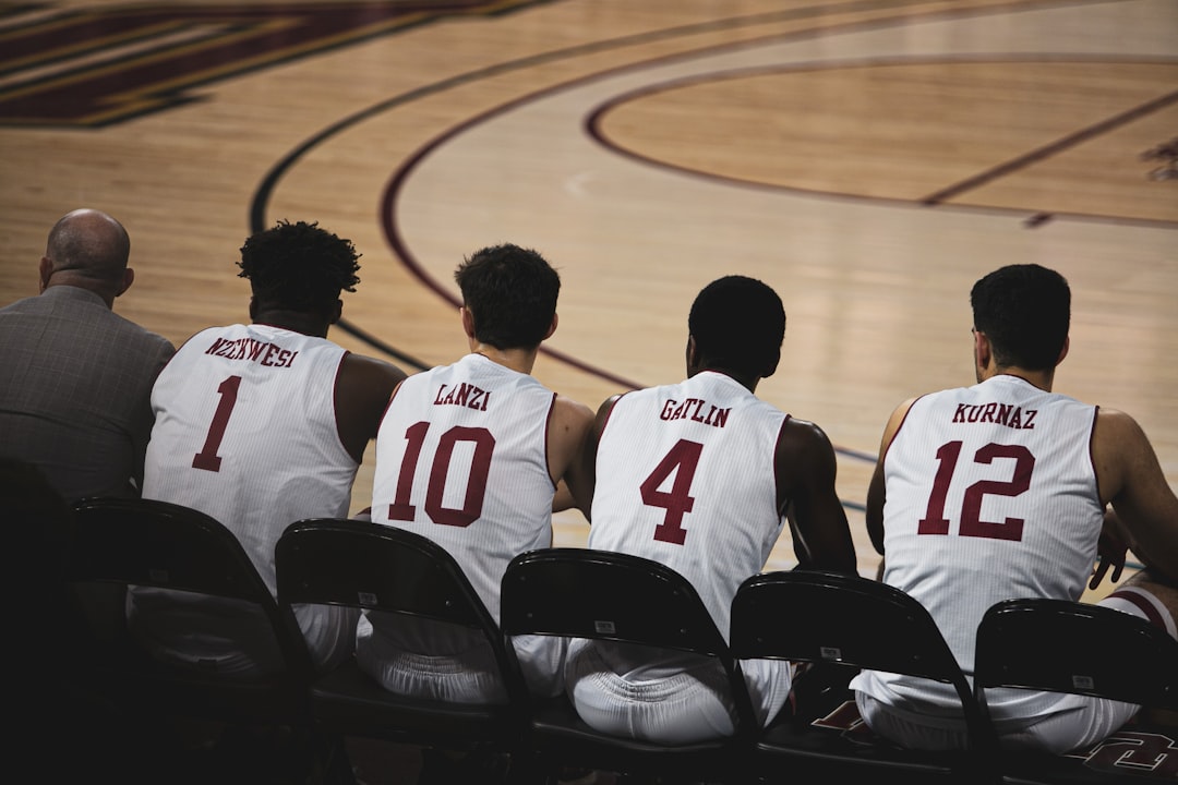 A diverse group of amateur basketball players filling out registration forms at a table with clipboards and documents, while a referee holds a rulebook, set in a bright community gym with basketball c